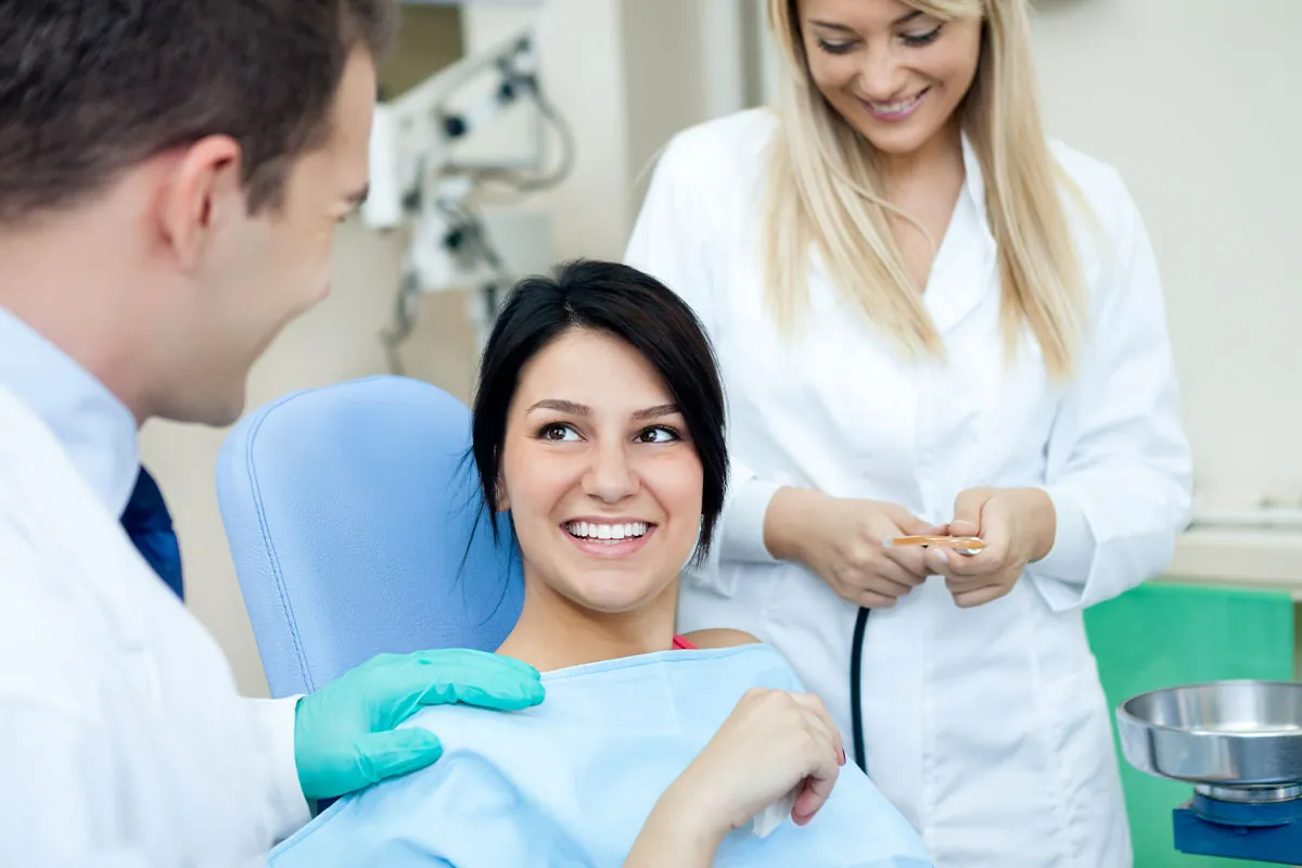 Beautiful woman smiling with dentist at dental
