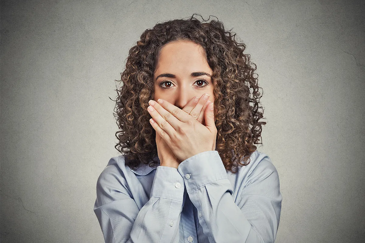 Beautiful girl closed her mouth by hands
