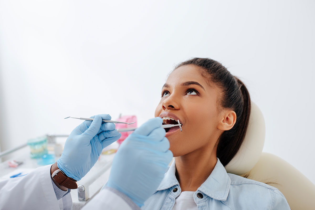 Dentist checking his patient's gum